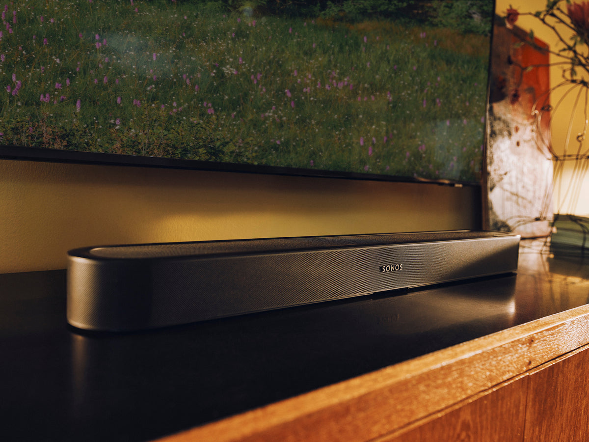 The soundbar in place under a wall-mounted TV